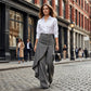 Asymmetrische wrap jeans 👖 Een combinatie van culottes en een pantalon, met een hoge taille voor een optisch langer lijkend effect, wijde pijpen en een zwierige pasvorm, en diagonaal geplaatste knopen – transformeer jezelf direct in een fashionista!